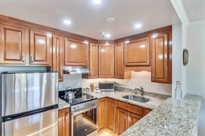 Wood cabinets, granite countertops and stainless steel appliances in a kitchen of an apartment at Piedmont Gardens