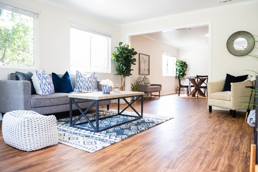 Living room with couch, coffee table, chair and rug in an apartment home at Redwood Terrace