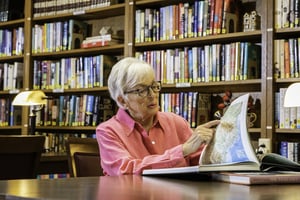 Senior woman reading a book in the library