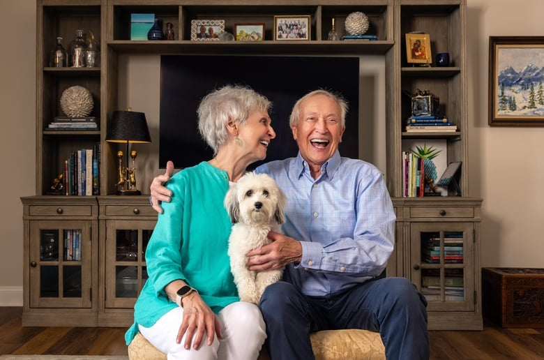 Mike and Linda from The Mansion at Rosemont smiling and holding their dog