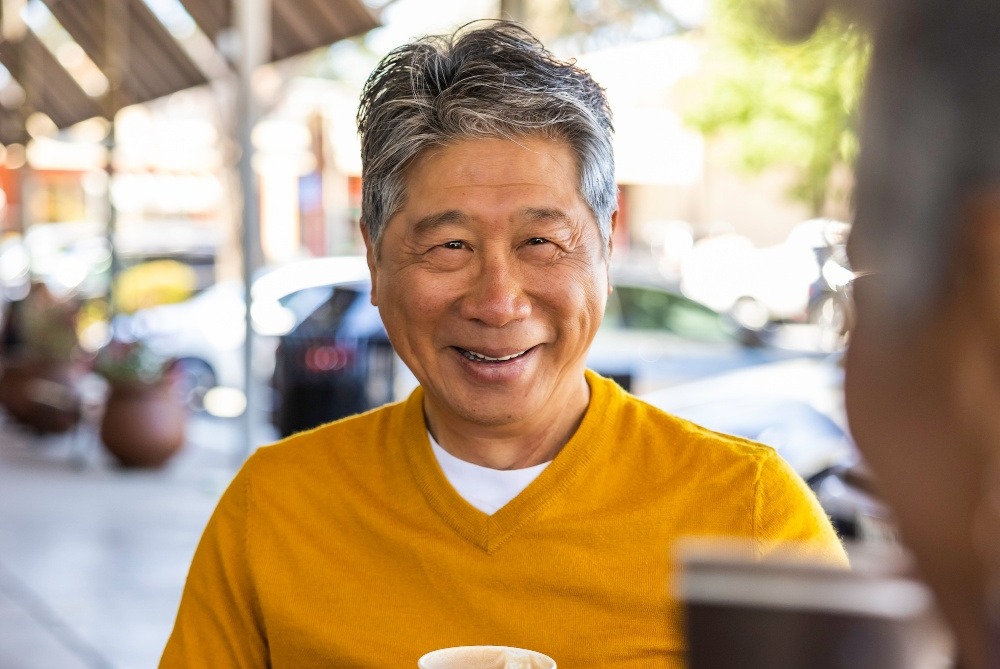 Man with yellow sweater drinking tea