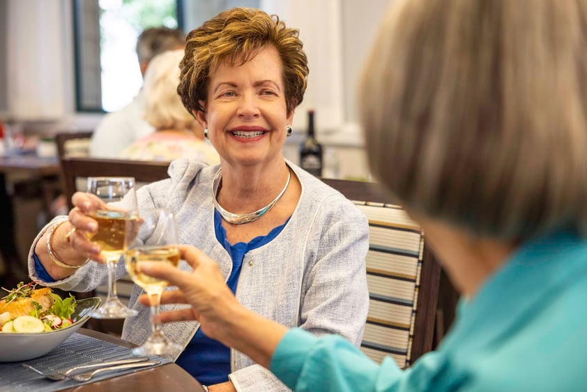 Two senior woman enjoying wine at lunch in the dining room of The Terraces of Los Gatos