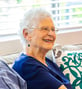 senior smiling in her living room