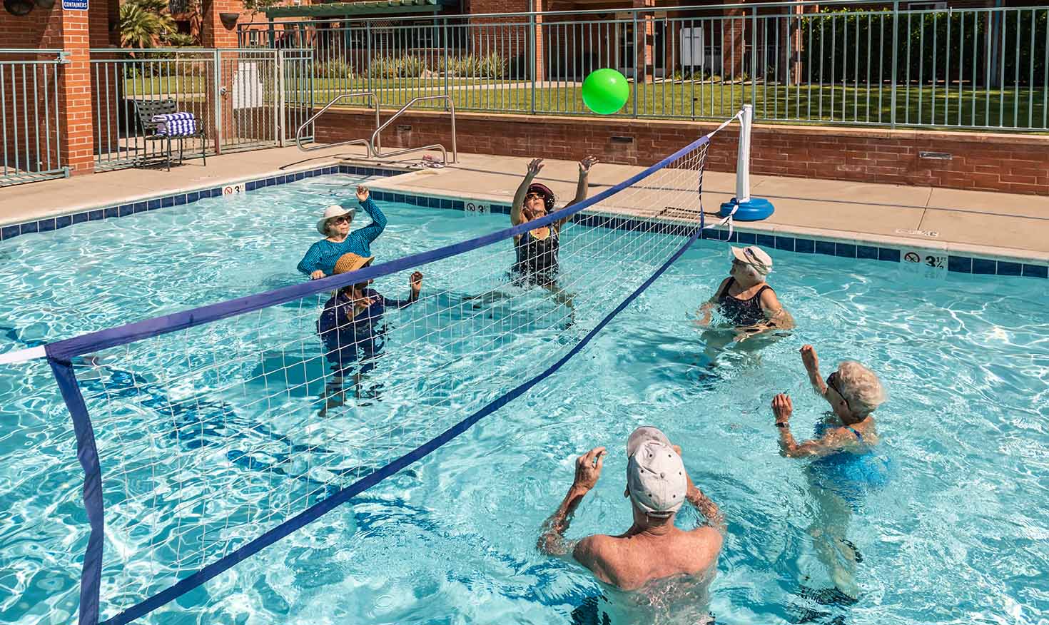 Group of seniors playing volleyball in the pool at Royal Oaks