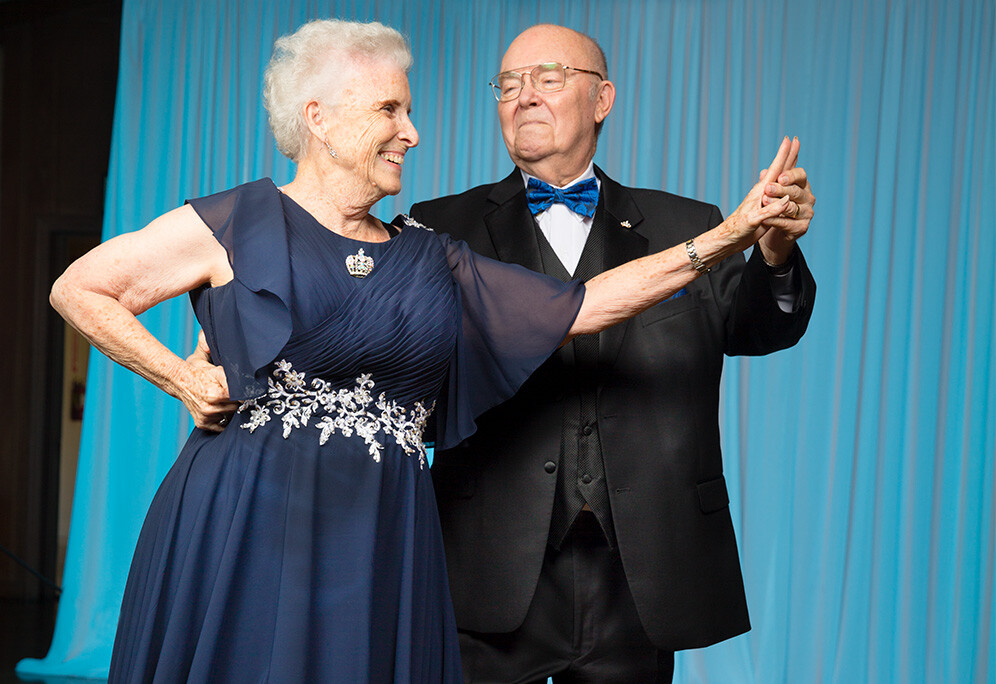 Susan and Chuck holding hands while dancing