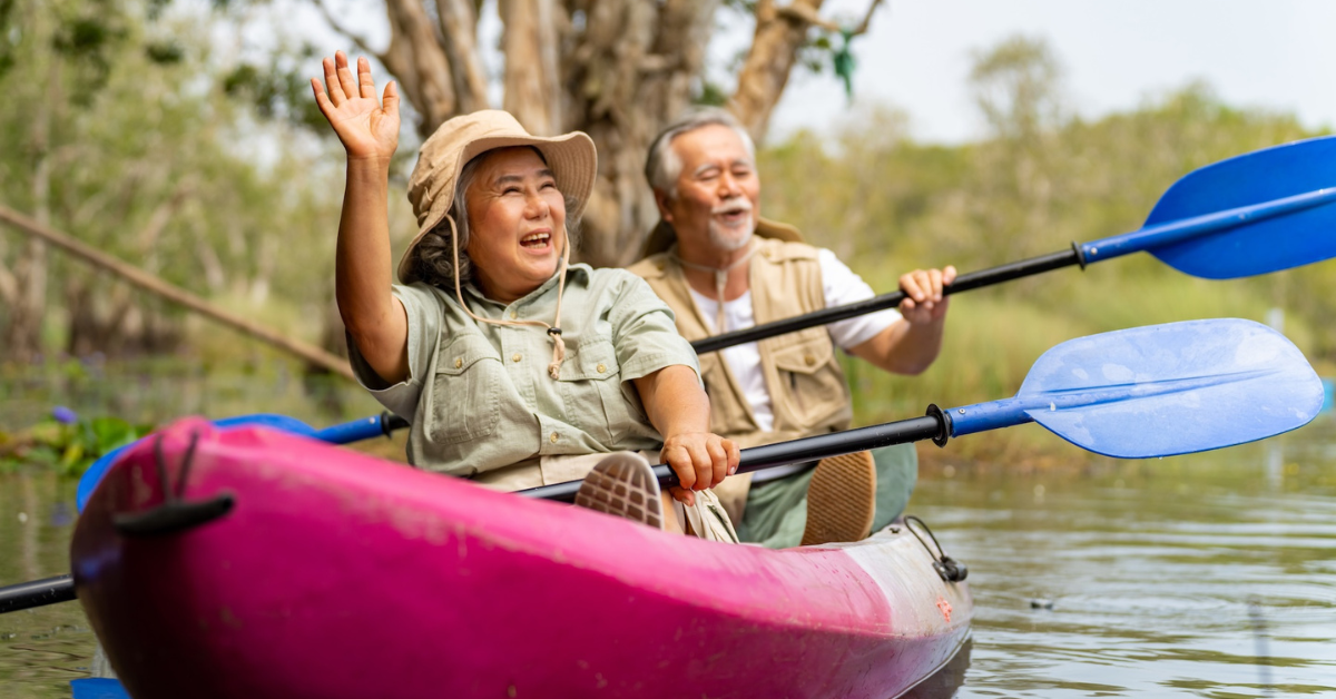 senior couple kayaking and smiling 