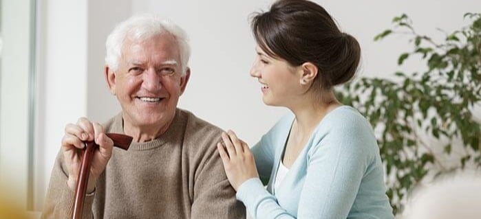 Caregiver woman on couch with older father