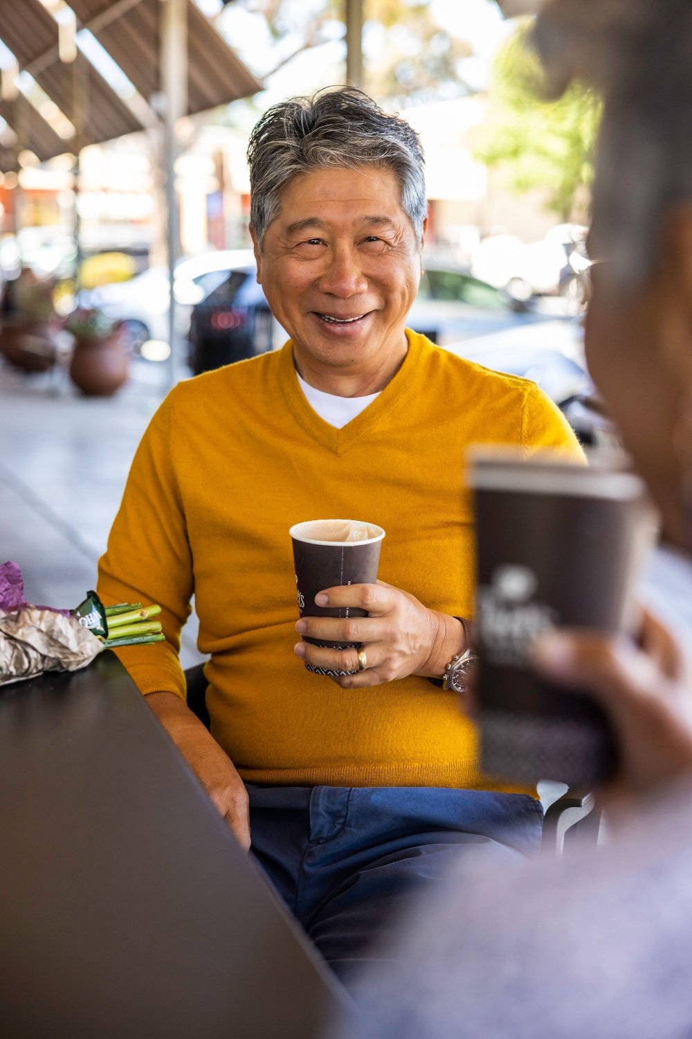 Man with yellow sweater drinking tea