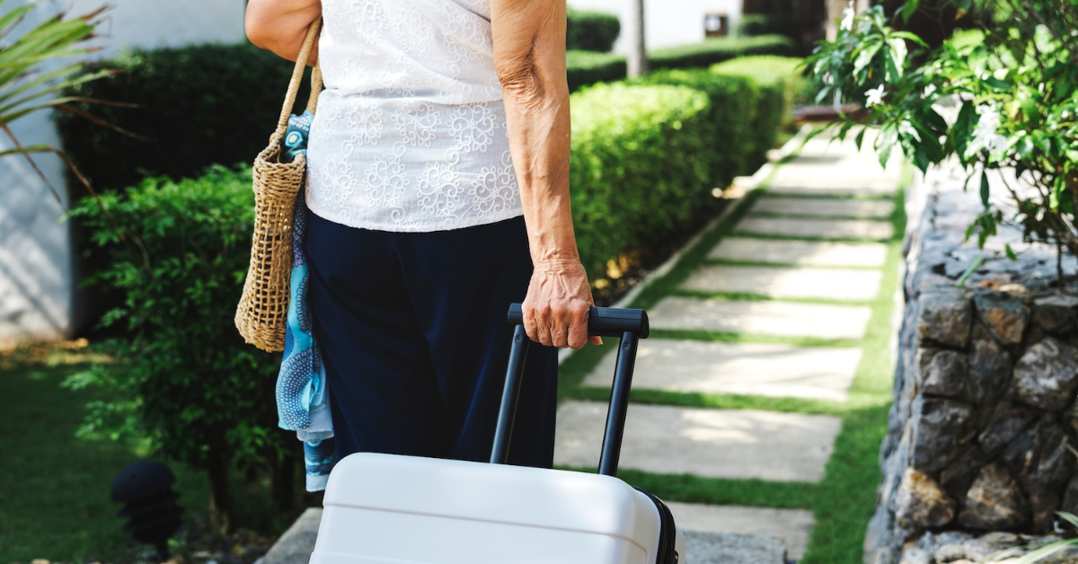 senior woman walking away from her lock and leave community to go on a trip