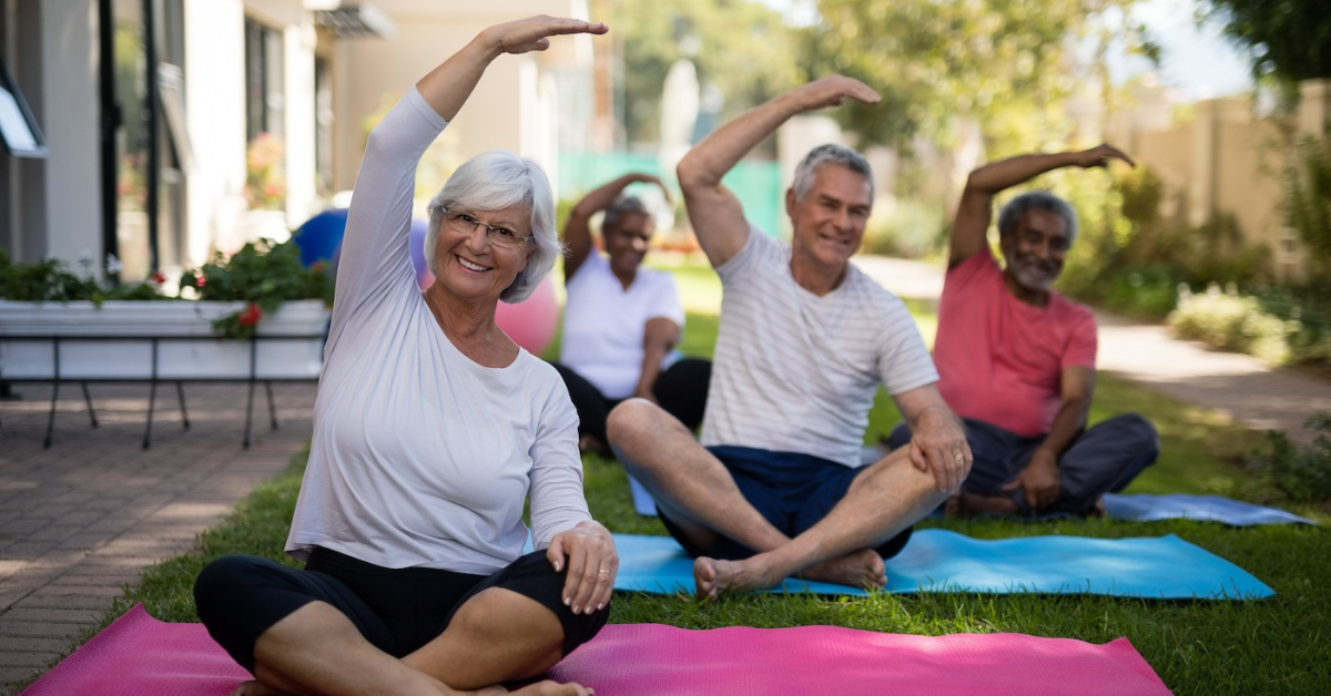 seniors working on their mobility and health at an outdoor yoga class