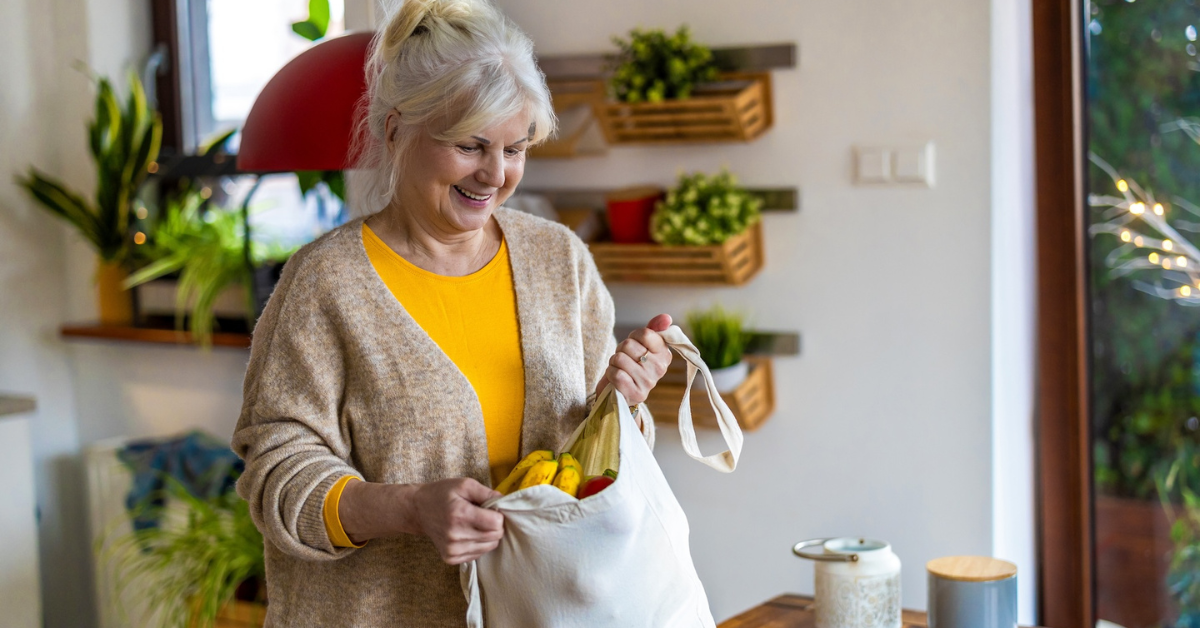 senior woman unpacking groceries out of reusable cloth grocery bag