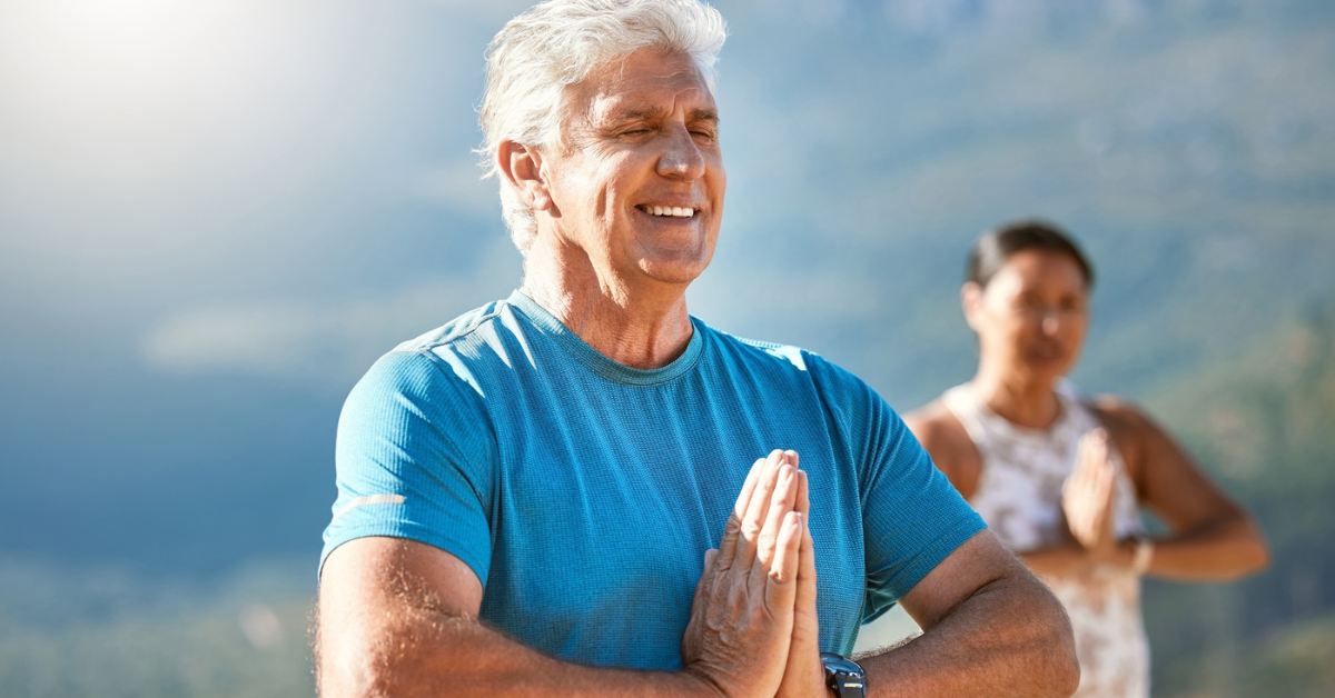 man practicing meditation outside with prayer hands and eyes closed