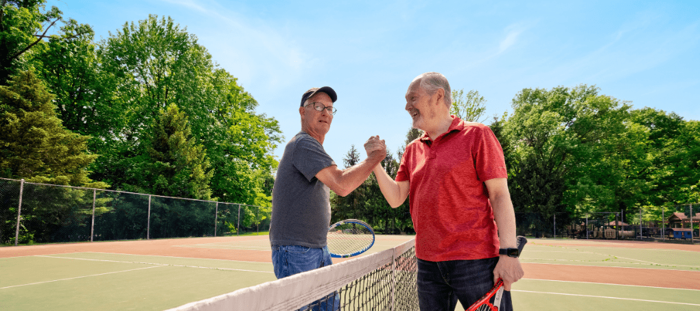 two men playing tennis together outside