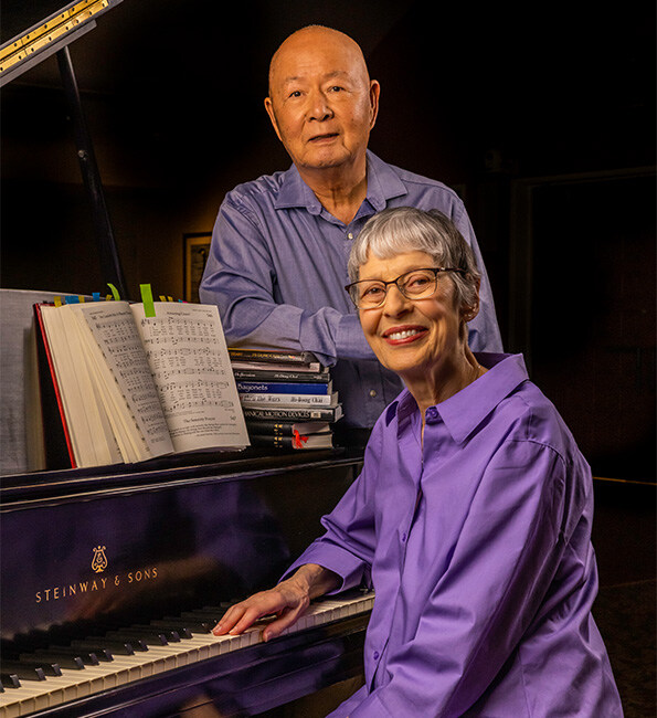 Hi-Dong and Phyllis posing next to a grand piano